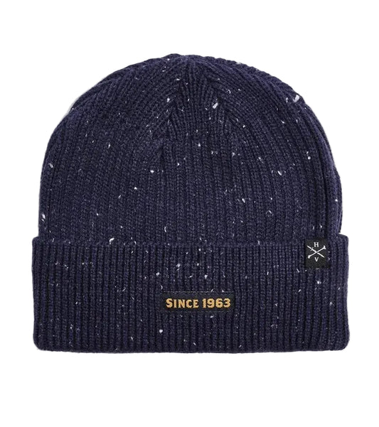 A navy blue knit x-men beanie with white speckles, featuring a black embroidered patch on the front cuff that reads 'XAVIER INSTITUTE' with a gold cross logo.