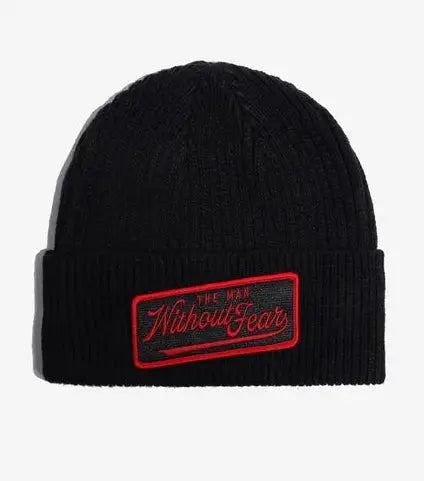 A black ribbed knit Marvel Daredevil beanie with a folded cuff, featuring a rectangular embroidered patch on the front that reads 'The Man Without Fear' in red and black.