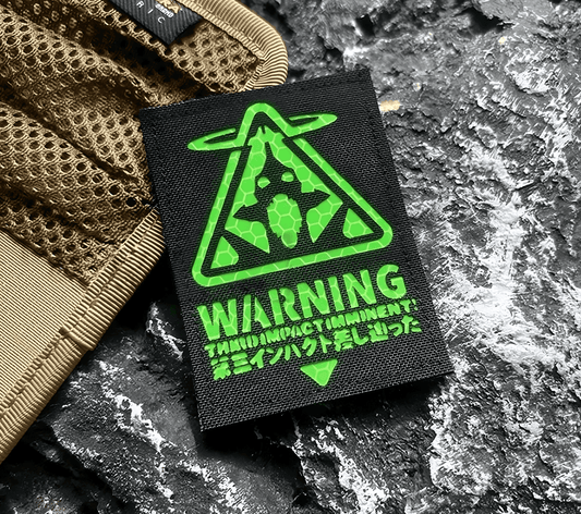 Black patch with green Evangelion Third Impact Reflective Hook & Loop Patch warning symbol and text on a white background