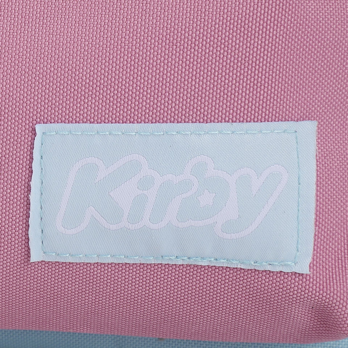 Close-up of a 'Kirby' label on pink fabric