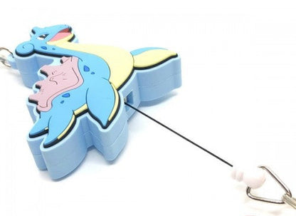 A blue and yellow pokemon lapras keychain or bag clip with a black retractable cord and a small metal ring, shown on a white background.