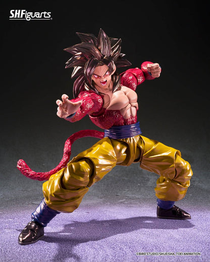 SH Figuarts Super Saiyan 4 goku action figure from Dragon Ball gt, standing in a dynamic pose with arms crossed over his chest. The figure features his signature metallic gold gi pants, a blue waistband, a pink Super Saiyan hairpiece, and a long pink tail, set against a dark studio background.