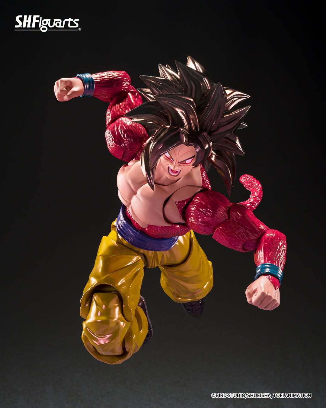 SH Figuarts Super Saiyan 4 goku action figure from Dragon Ball gt, standing in a dynamic pose with arms crossed over his chest. The figure features his signature metallic gold gi pants, a blue waistband, a pink Super Saiyan hairpiece, and a long pink tail, set against a dark studio background.