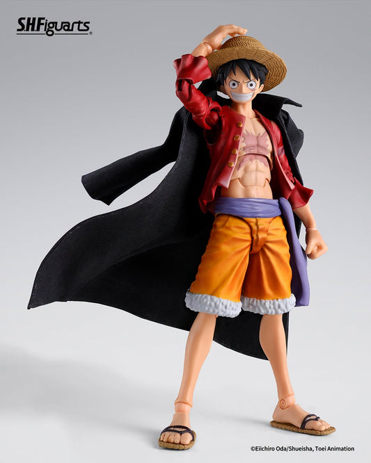SH Figuarts One Piece Luffy action figure in a dynamic pose, wearing his signature straw hat, red jacket, orange shorts, and black coat, set against a clean light gray studio background.