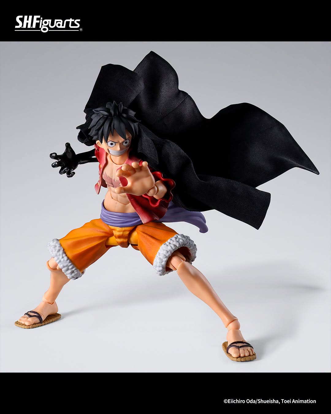 SH Figuarts One Piece Luffy action figure in a dynamic pose with his black cape flowing behind him, set against a light gray studio background.