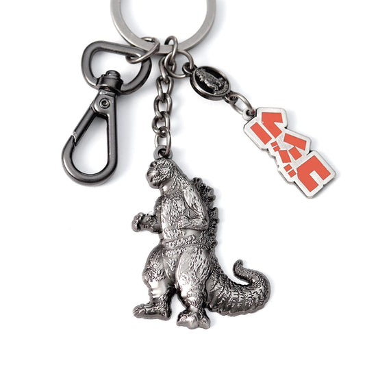 Metallic Godzilla keychain with charm and red logo on a white background