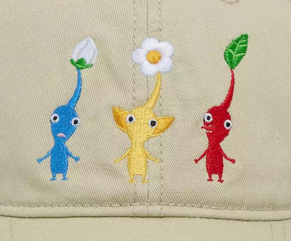 A beige baseball cap featuring embroidered Pikmin characters on the front panel, set against a plain white background.