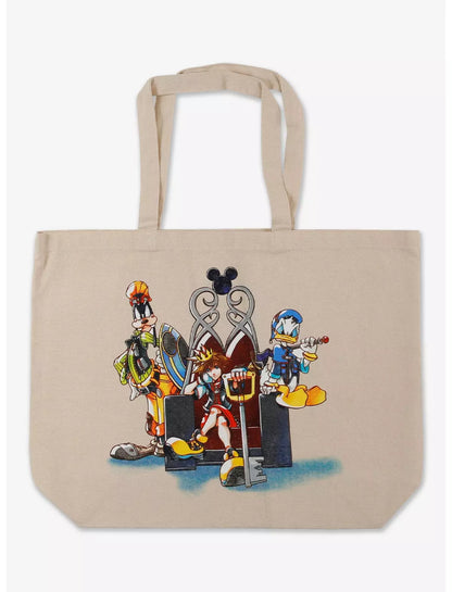A beige canvas tote bag featuring a colorful graphic print of Disney Kingdom characters including Goofy, Donald Duck, and Pluto standing in front of a silver throne.