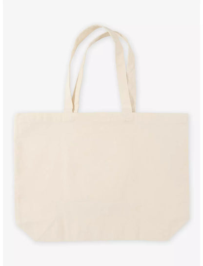 A plain canvas tote bag in a light cream or off-white color, shown against a clean white background. The bag has two long handles and no visible branding or graphics.