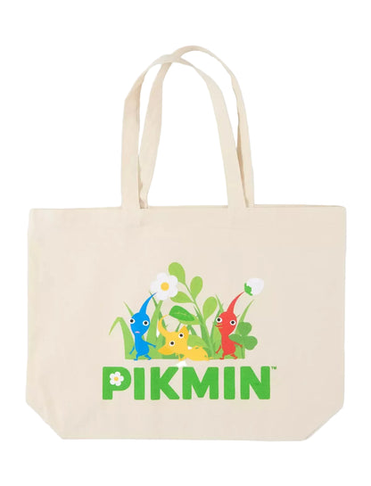 A beige canvas tote bag featuring a colorful graphic of Pikmin characters in green grass with the word 'PIKMIN' printed below in green, on a clean white background.