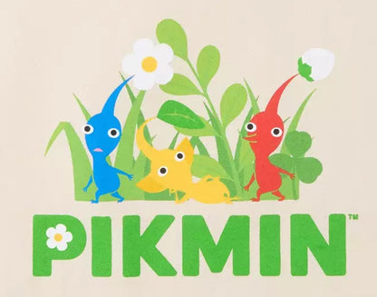 A beige canvas tote bag featuring a colorful graphic of Pikmin characters in green grass with the word 'PIKMIN' printed below in green, on a clean white background.