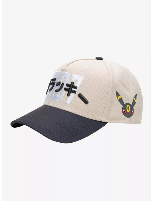 A structured baseball cap with a cream-colored crown, dark gray brim, and black embroidered Pokemon umbreon Japanese characters over large white and black  numerals on the front.