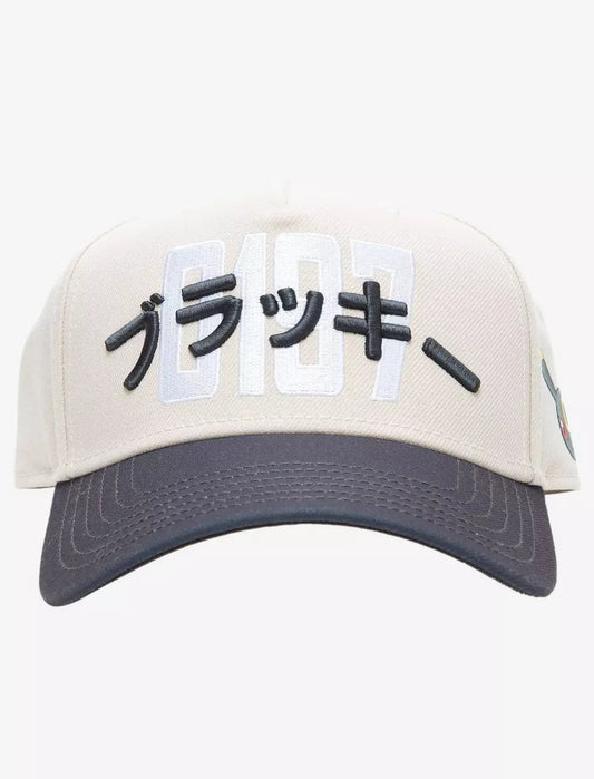 A structured baseball cap with a cream-colored crown, dark gray brim, and black embroidered Pokemon umbreon Japanese characters over large white and black  numerals on the front.