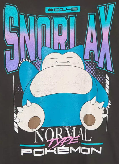 A black short-sleeve graphic T-shirt hanging on a wooden hanger against a light gray background. The shirt features a large front print with the word 'SNORLAX' in blue and purple, a blue and white Snorlax character, and the text 'NORMAL Type POKEMON' below.