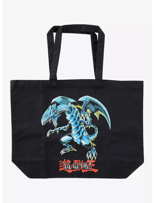 A black canvas tote bag featuring a large graphic print of the Yu-Gi-Oh! character Yugi's blue dragon, with red Yu-Gi-Oh! logo text underneath, shown against a plain white background.
