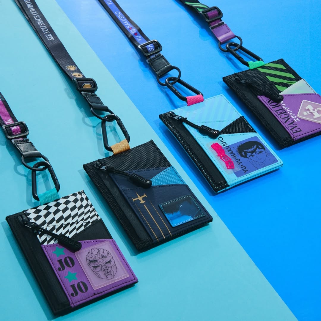 Collection of colorful JoJo’s Stone Mask, Eva Unit-01, Gon Freecss, or Yusuke lanyard wallet by Atsuko with attached card holders on a blue background