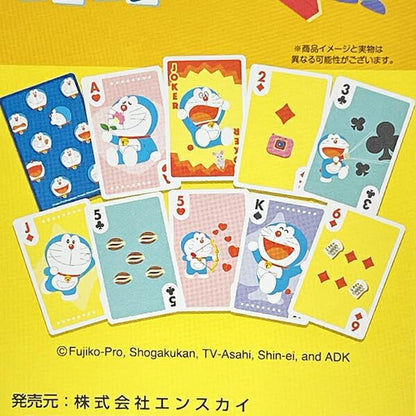 A set of Doraemon-themed playing cards displayed on a bright yellow background. The cards feature various suits and face values decorated with illustrations of Doraemon, his cat Neemo, and iconic scenes from his stories.