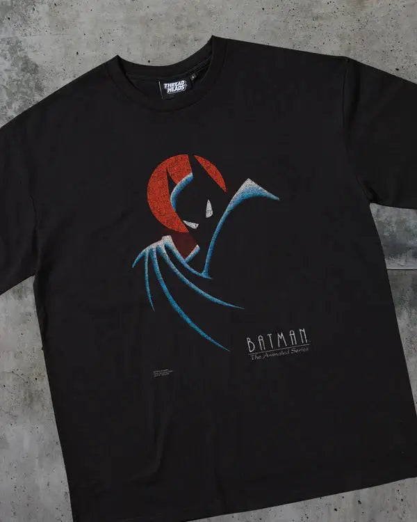 Black t-shirt with Batman graphic design on a concrete surface