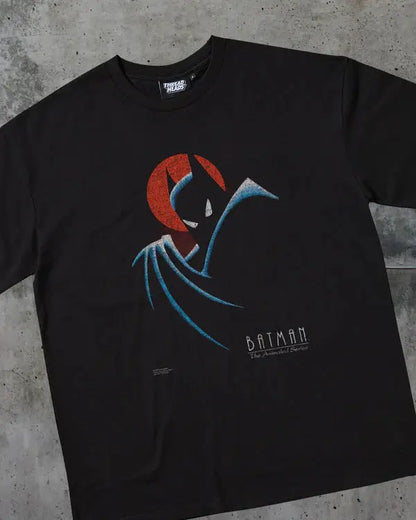 Black t-shirt with Batman graphic design on a concrete surface