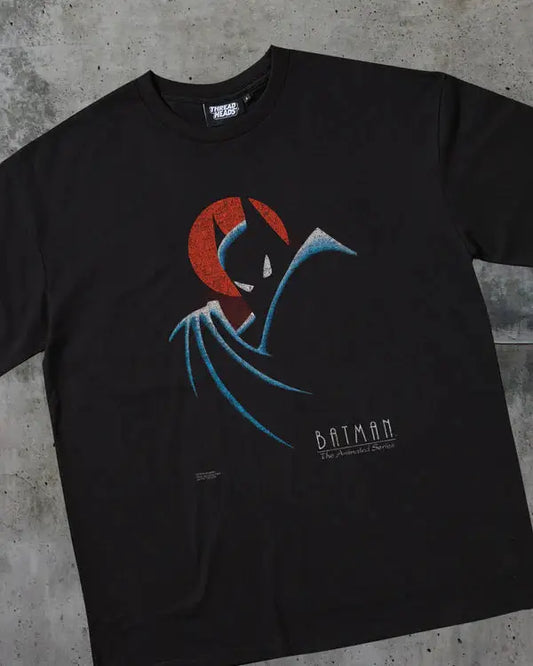 Black t-shirt with Batman graphic design on a concrete surface
