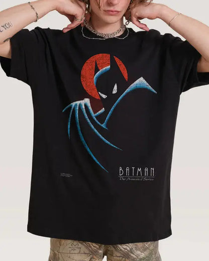 A person wearing an oversized black Batman graphic T-shirt with a stylized red and blue bat silhouette and the text 'BATMAN The Animated Series' on the front, photographed against a plain light background.