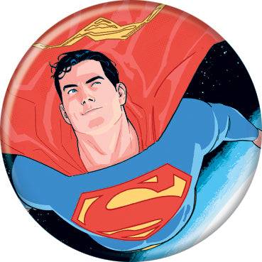 A round pinback button badge featuring a comic book illustration of Superman flying forward against a dark starry space background, with his red cape and blue suit visible.