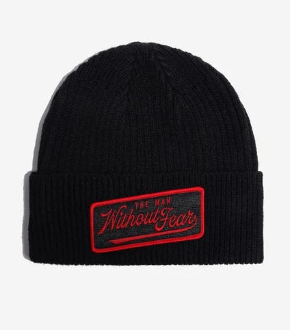 A black ribbed knit Marvel Daredevil  beanie with a folded cuff, featuring a rectangular embroidered patch on the front that reads 'The Man Without Fear' in red and black.