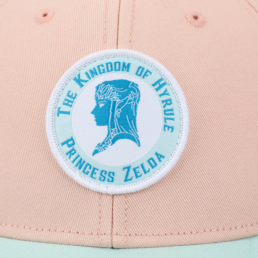 Pink and light blue cap with The Legend Of Zelda Princess Zelda Patch circular emblem on a white background