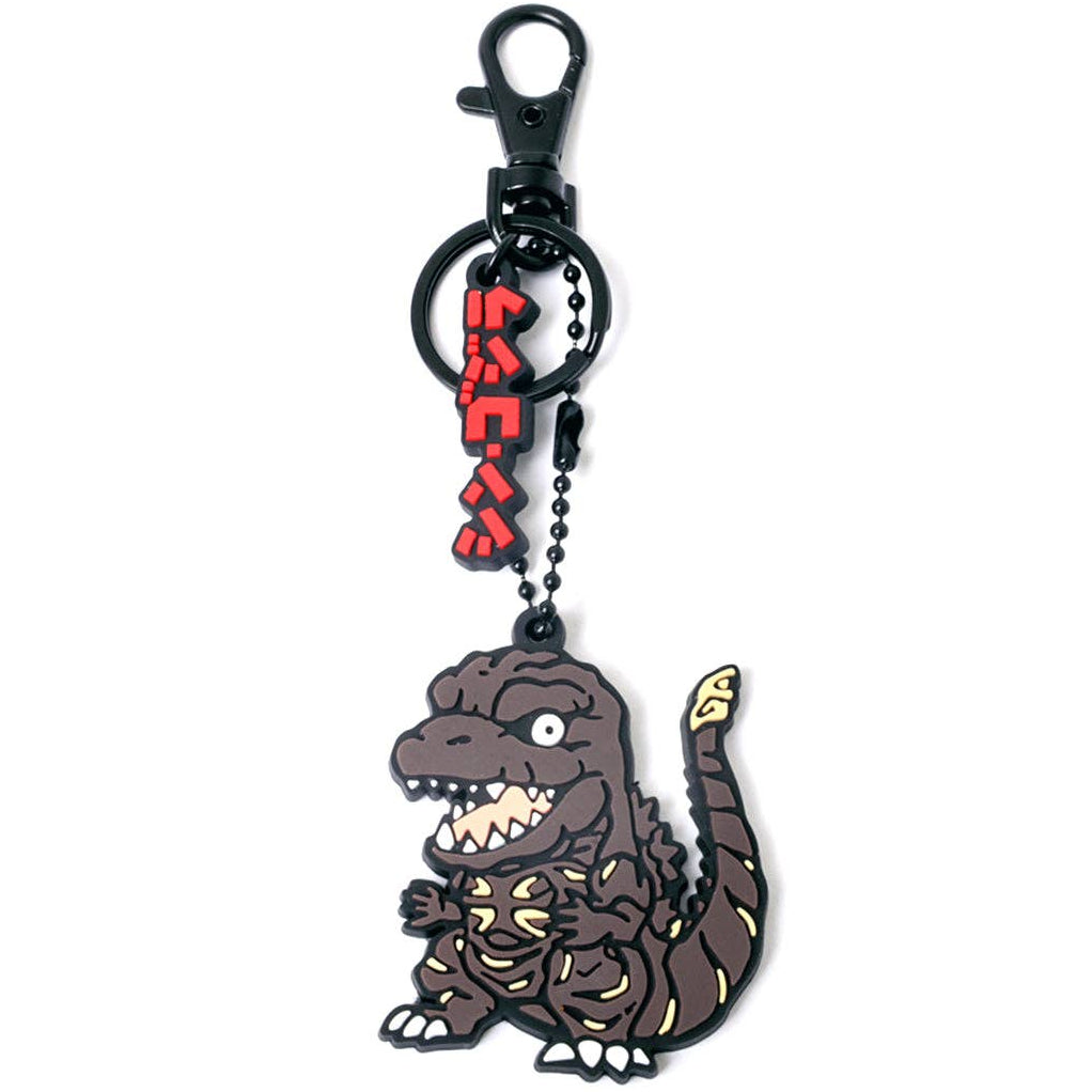 A chibi cartoon-style keychain featuring shin Godzilla character charm with yellow markings, attached to a black ball chain and clasp, with red Japanese text hanging above.