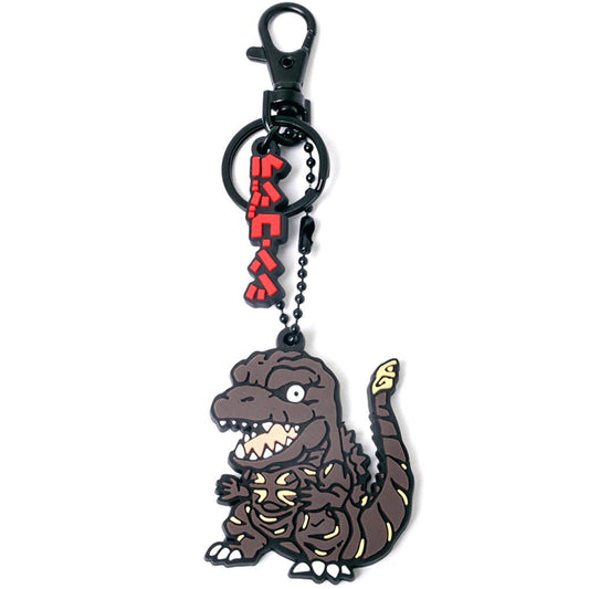 A chibi cartoon-style keychain featuring shin Godzilla character charm with yellow markings, attached to a black ball chain and clasp, with red Japanese text hanging above.