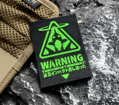 Black patch with green Evangelion Third Impact Reflective Hook & Loop Patch warning symbol and text on a white background