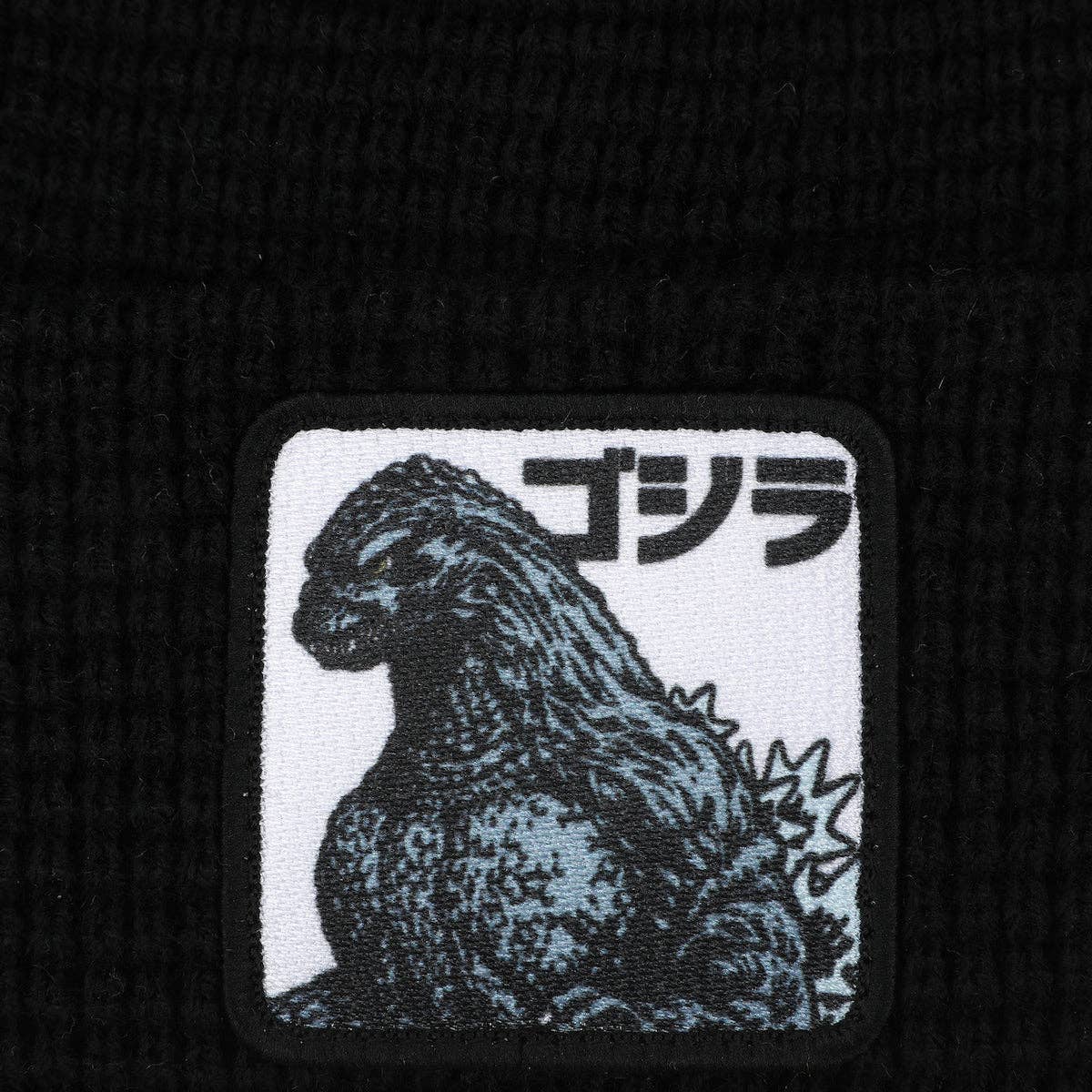 Embroidered patch of Godzilla with Japanese text on a black background