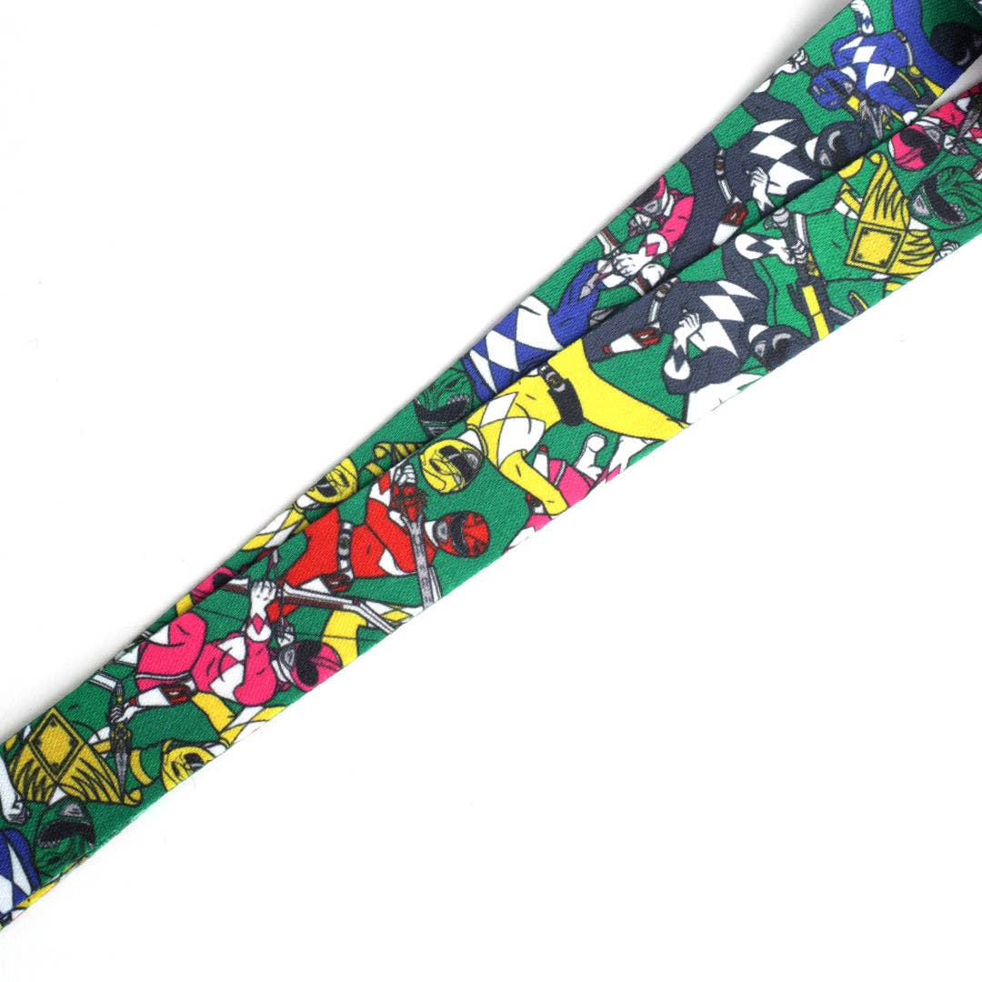 A multicolor Power Rangers patterned lanyard strap with a green webbed section, black plastic buckle, and black carabiner clip, shown on a plain white background.