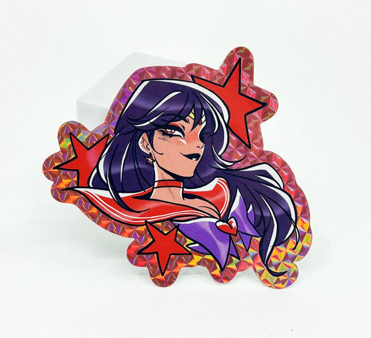 A die-cut holographic sticker featuring an anime-style Sailor moon Sailor scout Mars character with long dark purple hair, wearing a red and purple outfit, surrounded by red stars, displayed on a white background.