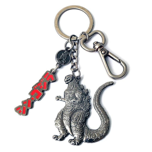 A metal keychain featuring a detailed silver Godzilla figure, a red and black Japanese katakana 'Godzilla' charm, and a silver clasp on a white background.